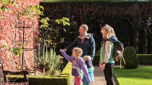 A family exploring the autumn colours in the garden at Chirk Castle and Garden, Wrexham.
